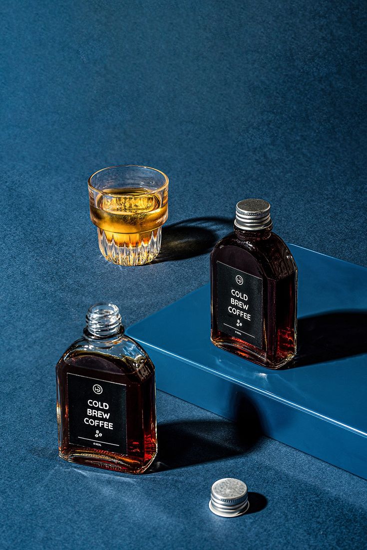 Koyu mavi fonda Cold Brew Coffee şişeleri